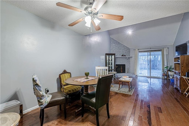 9215 E 85th St, Raytown, MO 64138 - dining space with lofted ceiling, a fireplace, a textured ceiling, ceiling fan, and hardwood / wood-style flooring