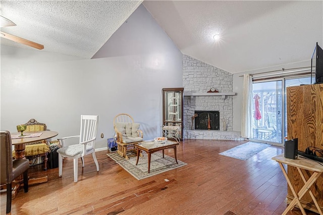 9215 E 85th St, Raytown, MO 64138 - living area featuring a textured ceiling, wood finished floors, a ceiling fan, and a stone fireplace