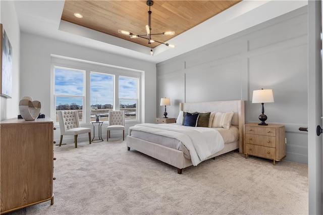 carpeted bedroom with an inviting chandelier, wood ceiling, and a tray ceiling