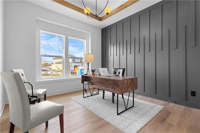 home office with a notable chandelier and light wood-type flooring