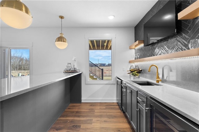 bar with wine cooler, sink, hanging light fixtures, dark hardwood / wood-style flooring, and decorative backsplash