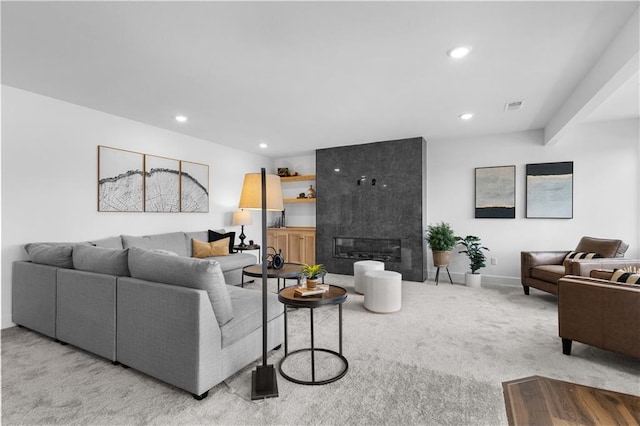 living room with a tiled fireplace and light colored carpet