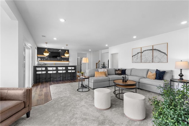 living room with bar and hardwood / wood-style floors