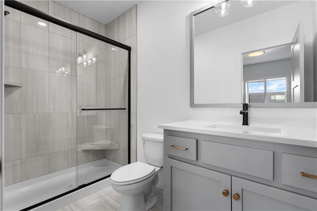 bathroom with vanity, a shower with door, and toilet