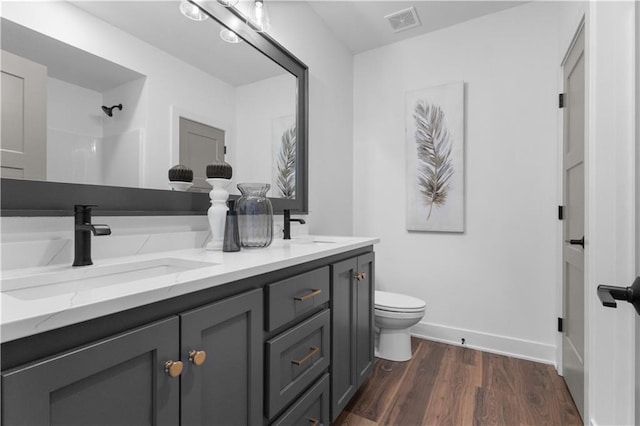 bathroom with vanity, toilet, hardwood / wood-style floors, and walk in shower