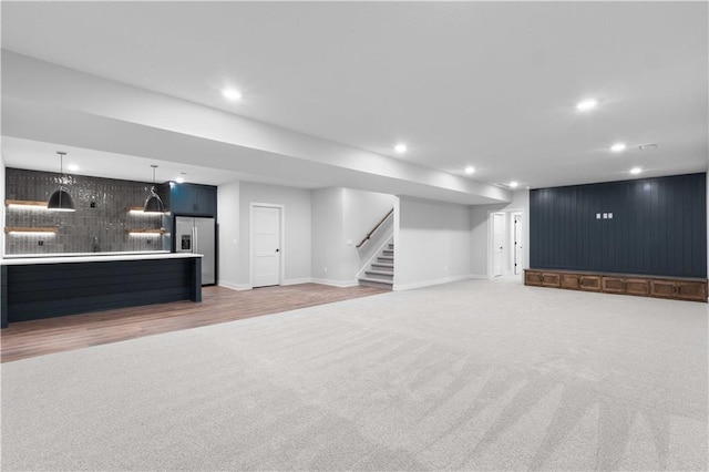 17186 S Heatherwood St, Olathe, KS 66062 - unfurnished living room with light carpet, stairway, recessed lighting, baseboards, and bar