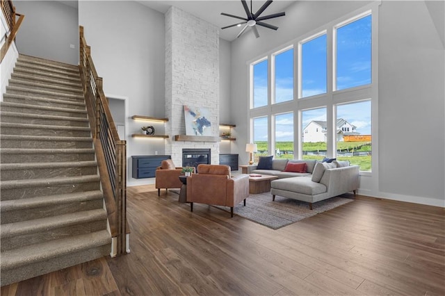 17186 S Heatherwood St, Olathe, KS 66062 - living room with a towering ceiling, stairway, a fireplace, dark wood-style flooring, and plenty of natural light