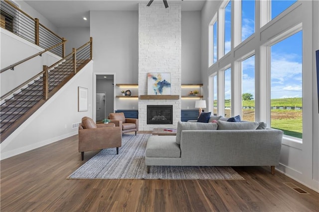 17186 S Heatherwood St, Olathe, KS 66062 - living room with a towering ceiling, baseboards, dark wood-style floors, a stone fireplace, and stairway