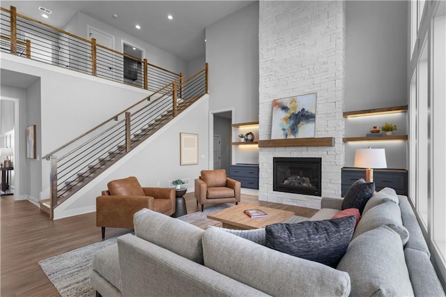 17186 S Heatherwood St, Olathe, KS 66062 - living area with a high ceiling, wood finished floors, a fireplace, stairs, and baseboards