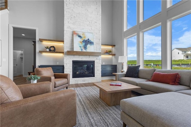 17186 S Heatherwood St, Olathe, KS 66062 - living area featuring a high ceiling, a stone fireplace, and wood finished floors