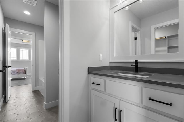 17186 S Heatherwood St, Olathe, KS 66062 - ensuite bathroom with vanity, baseboards, tile patterned floors, a tub, and recessed lighting