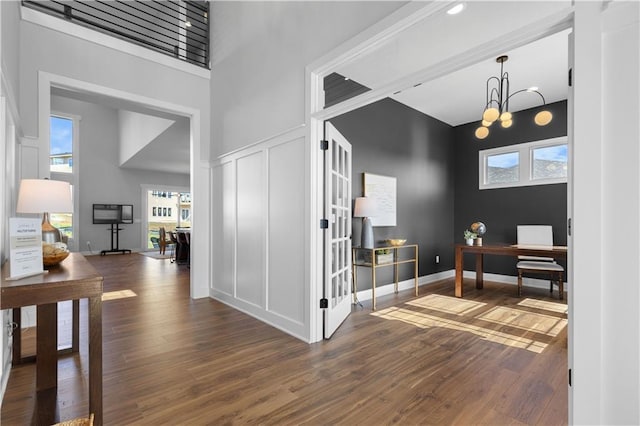 17186 S Heatherwood St, Olathe, KS 66062 - entryway featuring dark wood finished floors, plenty of natural light, a high ceiling, a decorative wall, and baseboards