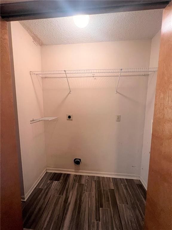 clothes washing area with dark wood-style floors, baseboards, laundry area, electric dryer hookup, and a textured ceiling