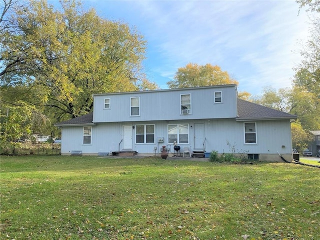 rear view of house with entry steps and a yard