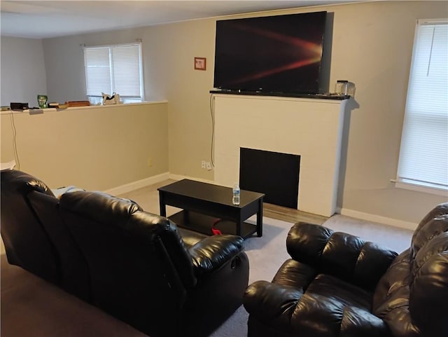 carpeted living room featuring a tile fireplace