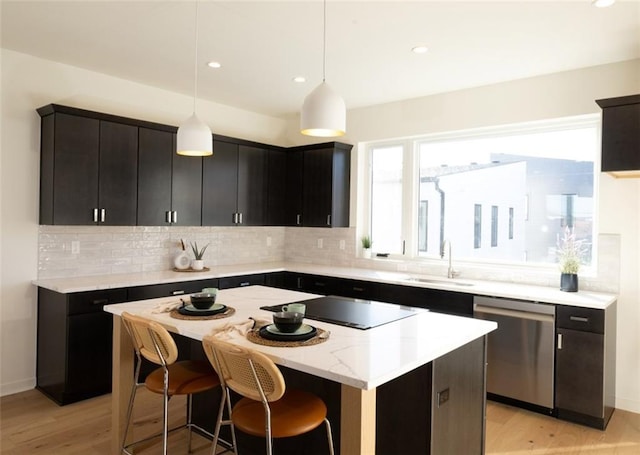 kitchen with a kitchen island, tasteful backsplash, dishwasher, and light wood-style flooring