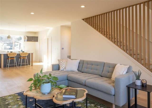 living area featuring recessed lighting, light wood-style flooring, and stairs