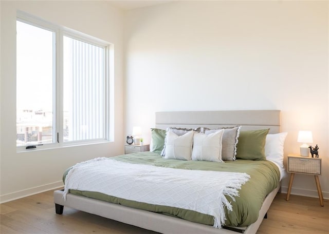 bedroom with wood finished floors and baseboards