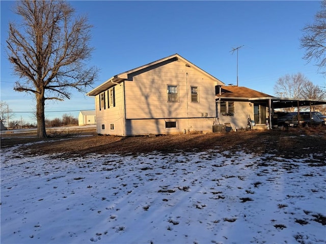 view of snow covered exterior with central AC unit