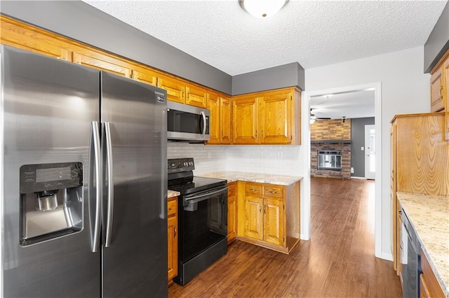 kitchen featuring stainless steel appliances, light stone counters, a textured ceiling, and decorative backsplash