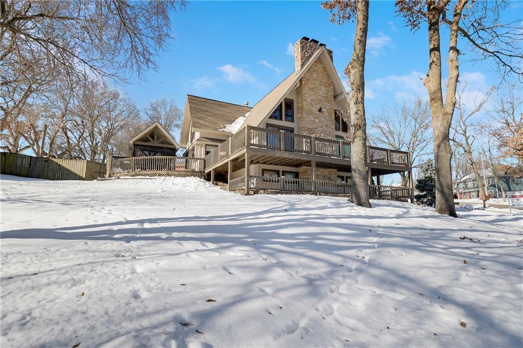 snow covered back of property featuring a wooden deck