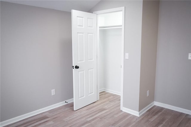 unfurnished bedroom with light wood-type flooring and a closet