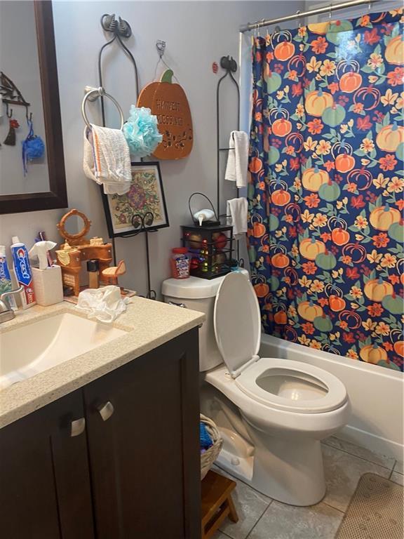 full bath with toilet, shower / tub combo with curtain, vanity, and tile patterned flooring