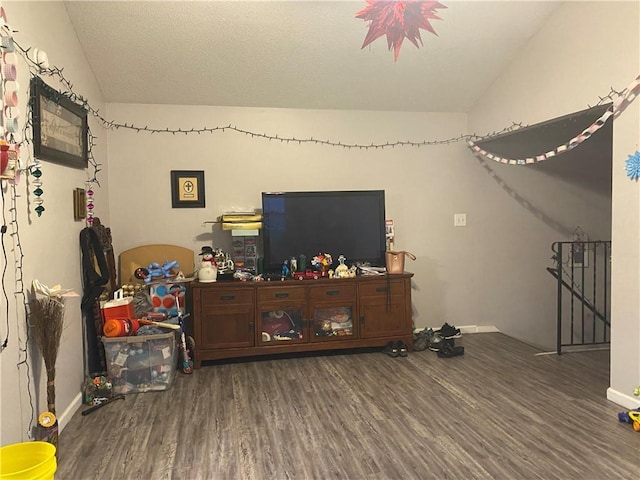 living area with baseboards, wood finished floors, and vaulted ceiling