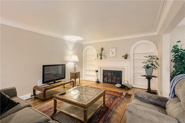 living room with hardwood / wood-style flooring, crown molding, and built in shelves