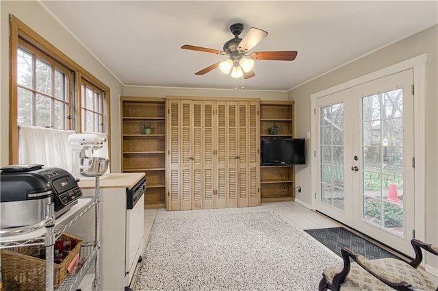 tiled home office with french doors, ceiling fan, and ornamental molding