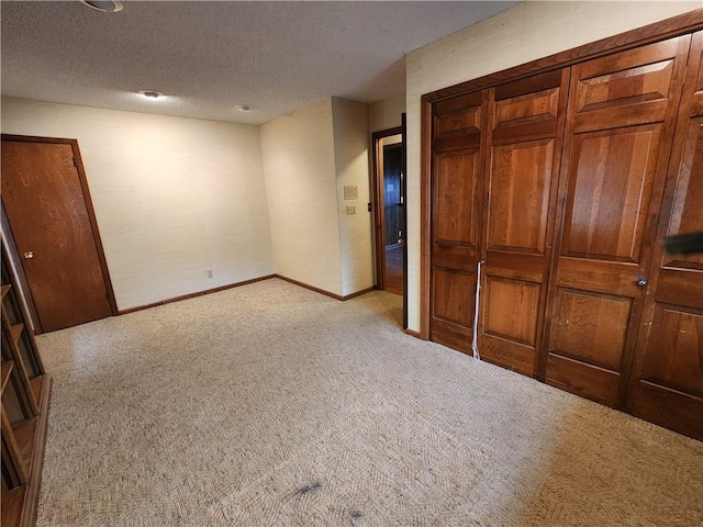 unfurnished bedroom with light colored carpet and a textured ceiling