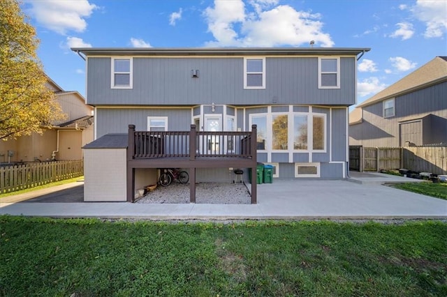 back of property featuring a patio area, a deck, and a yard