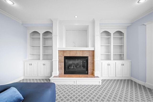 living room with light colored carpet, a tiled fireplace, built in features, and crown molding