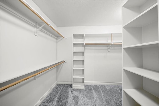 spacious closet featuring dark carpet