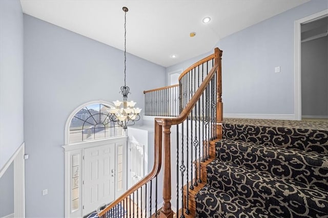 staircase featuring a chandelier and carpet floors