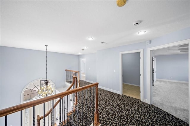 corridor featuring carpet and a notable chandelier