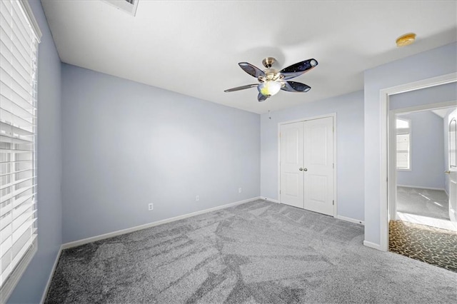 unfurnished bedroom with ceiling fan, a closet, and carpet floors