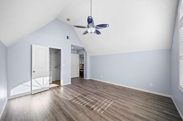 additional living space with ceiling fan, vaulted ceiling, dark wood-type flooring, and a wealth of natural light