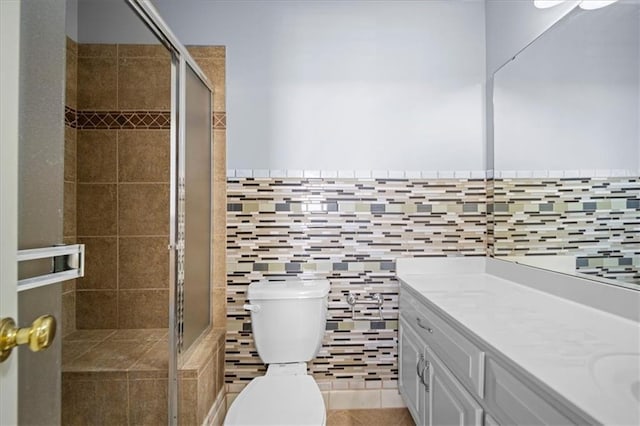 bathroom featuring toilet, tile patterned floors, an enclosed shower, and vanity