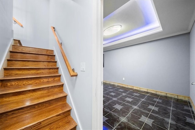 stairway featuring crown molding and a tray ceiling