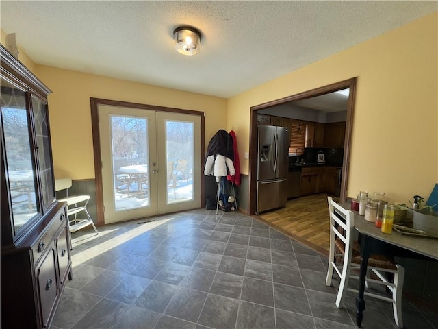 doorway featuring french doors, dark hardwood / wood-style floors, and a textured ceiling