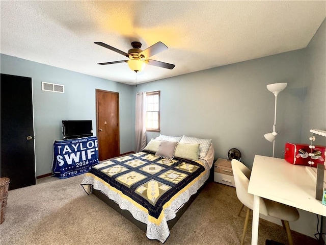 carpeted bedroom featuring ceiling fan and a textured ceiling