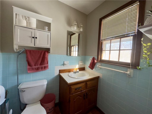 bathroom with tile walls, toilet, and vanity