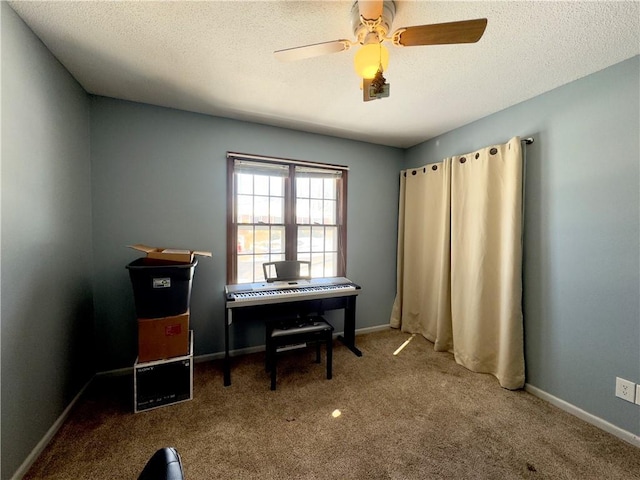 home office featuring a textured ceiling, ceiling fan, and carpet