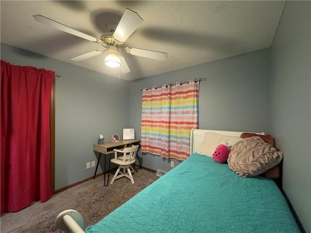 carpeted bedroom featuring ceiling fan and a textured ceiling