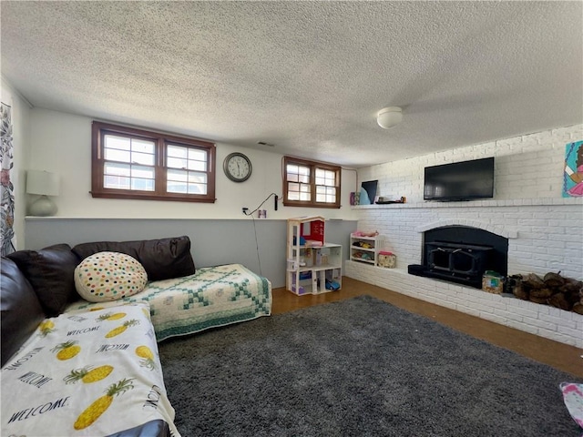 living room with plenty of natural light, a wood stove, and a textured ceiling