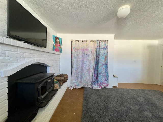 interior space with a wood stove and a textured ceiling