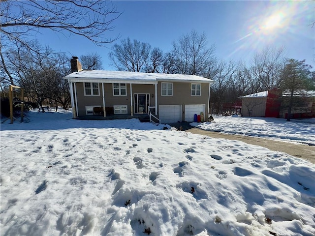 snow covered property with a garage