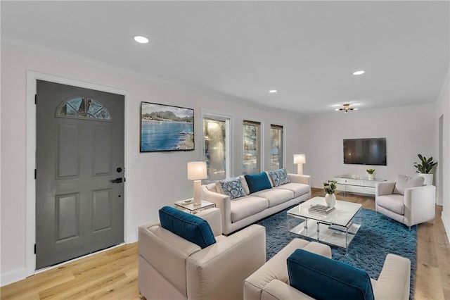 living room with light wood-type flooring and crown molding