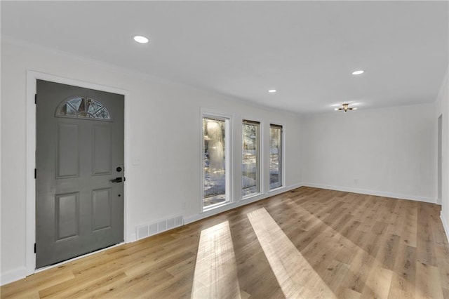 entryway featuring light hardwood / wood-style floors and crown molding